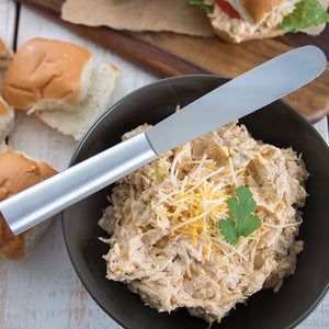 Silver handle Super Spreader with chicken dip and cheese in a bowl.