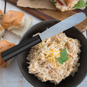 Black handle Super Spreader with chicken dip and cheese in a bowl.