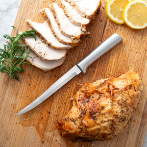 Silver handle knife of a cutting board with chicken and lemon