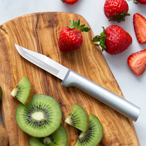 Silver handle knife on a cutting board with strawberries and kiwi