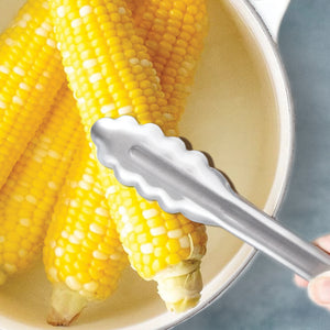 9" Tongs picking up a cooked piece of corn on the cob.