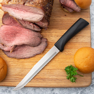 Non-serrated Rada Cutlery Anthem Wave Slicer on cutting board with sliced meat