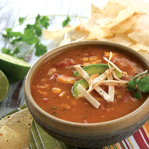 Prepared Chicken Tortilla Soup in a bowl garnished with avocado slices, tortilla strips, and parsley