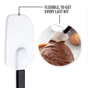 A flexible spatula scraping the sides of a bowl of brownie batter. Flexible, to get every last bit.