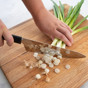 Using black handle French Chef to chop onions for cooking.