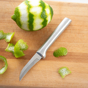 Silver Granny Paring with a peeled lime on a cutting board and lime peels surround it.