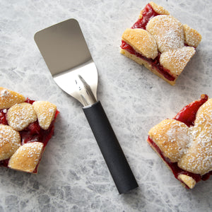 Black handle server laying next to baked cherry bars.