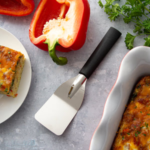 Rada's Mini Server next to a pan of egg bake, a piece of egg bake on a plate, peppers, and greenery.