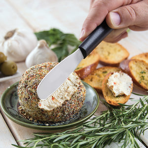 Party Spreader with black handle in use spreading cheeseball. 