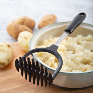 Rada Potato Masher laying flat on bowl of mashed potatoes.