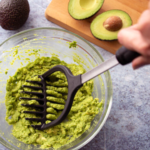 Rada's non-scratch Potato Masher mashing avocados in a bowl to make guacamole.