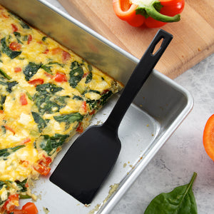 Serving a pan of feta and spinach quiche with the one-piece nylon potluck spatula.