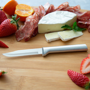 An aluminum handled regular paring knife on a cutting board with slices of cheese, prosciutto, strawberries and oranges.
