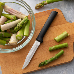 Rada black handle Serrated Regular Paring laying down, aimed down next to asparagus.