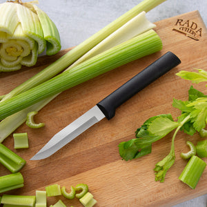 Black handle Serrated Regular Paring on a Rada Cutlery cutting board and chopped celery.
