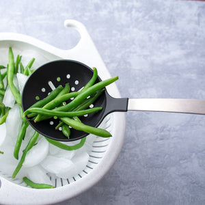 Non-scratch Skimmer straining green beans into ice and strainer.