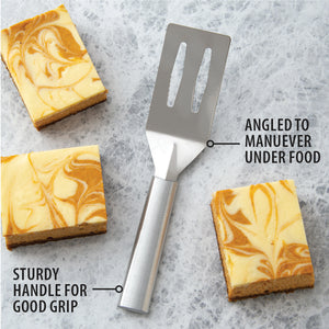 A brushed aluminum handled spatula serving dessert bars. Angled to maneuver under food. Sturdy handle for good grip.