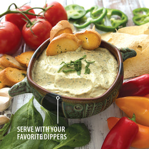 Serve with your favorite dippers. A bowl of spinach artichoke dip with bread, tortilla chips, sweet peppers and tomatoes.