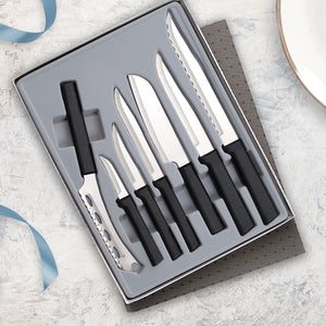 The seven piece Rada Cutlery Starter Gift Set Part 2 with black handles on a marble countertop with a blue ribbon.