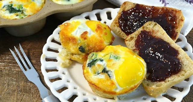 Breakfast casserole bites next to slices of whole grain grape jellied toast with a three-pronged fork