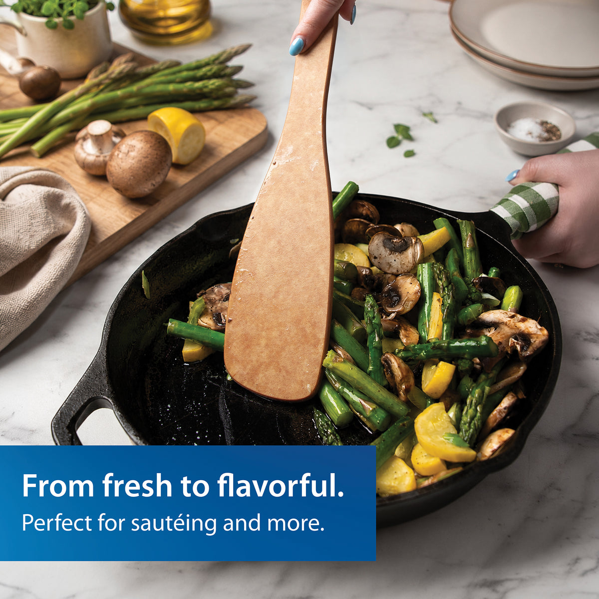 Rada's wooden Heavy-Duty Saute Spoon used for sauteing vegetables in a black cast iron skillet. A hand holds the handle, and a ble text banner at the bottom reads 'From fresh to flavorful.'