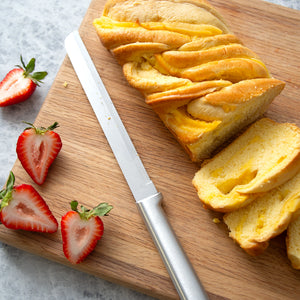 Rada's Bread Knife along with cut strawberries and sliced lemon bread shown on a cutting board.