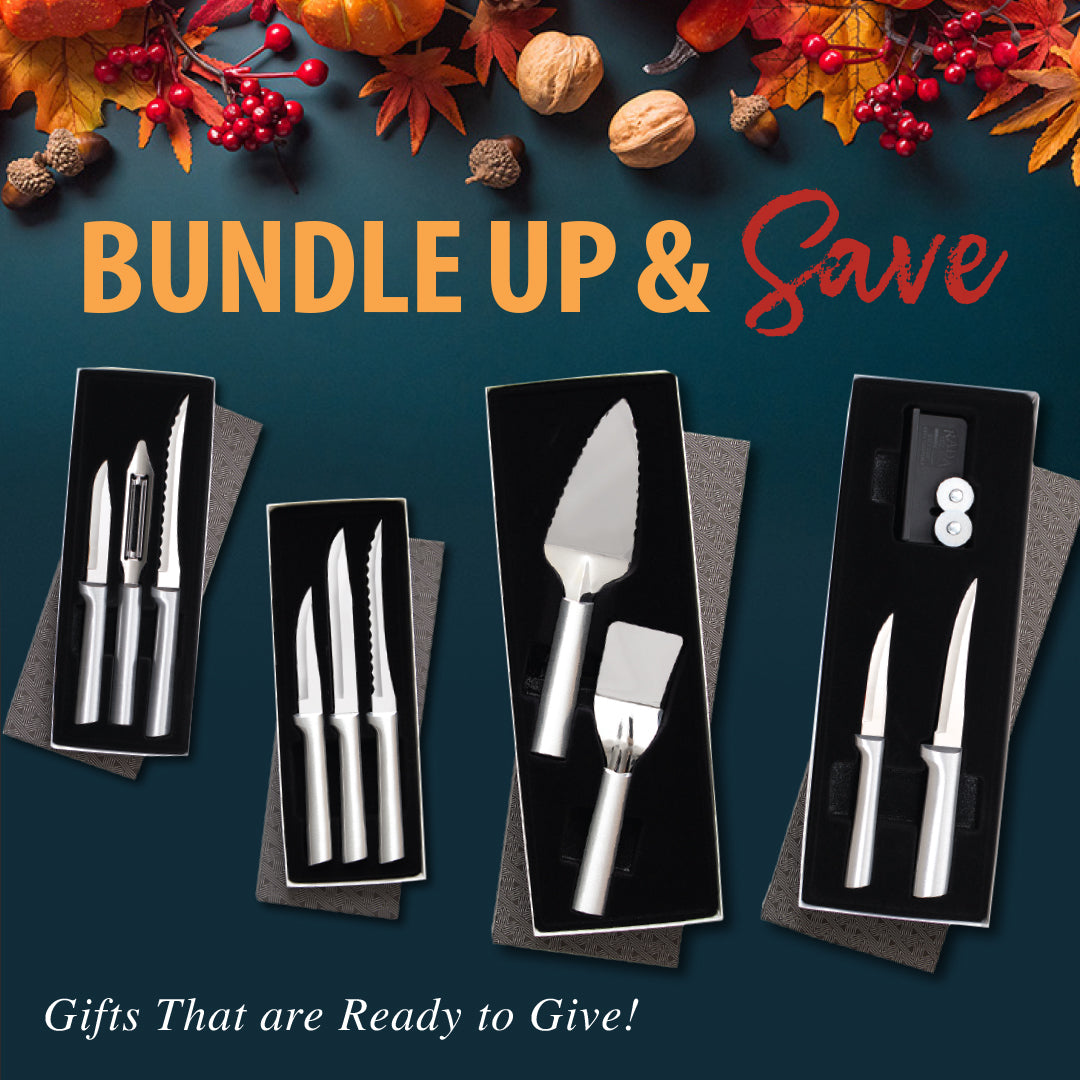 Set of silver cutlery in black boxes with autumn leaves and berries on a blue background.