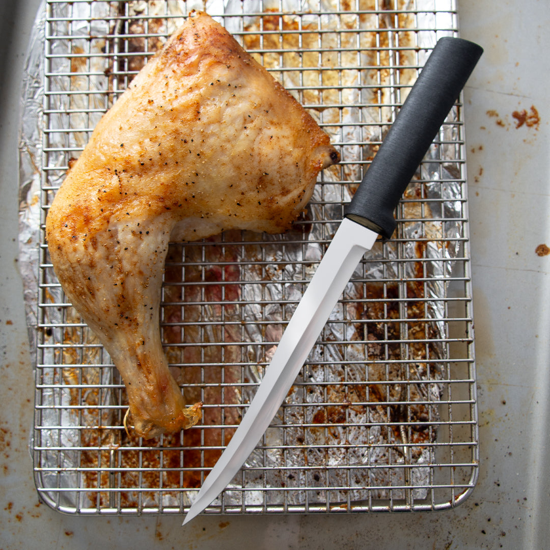 Silver handle knife of a cutting board with chicken and lemon