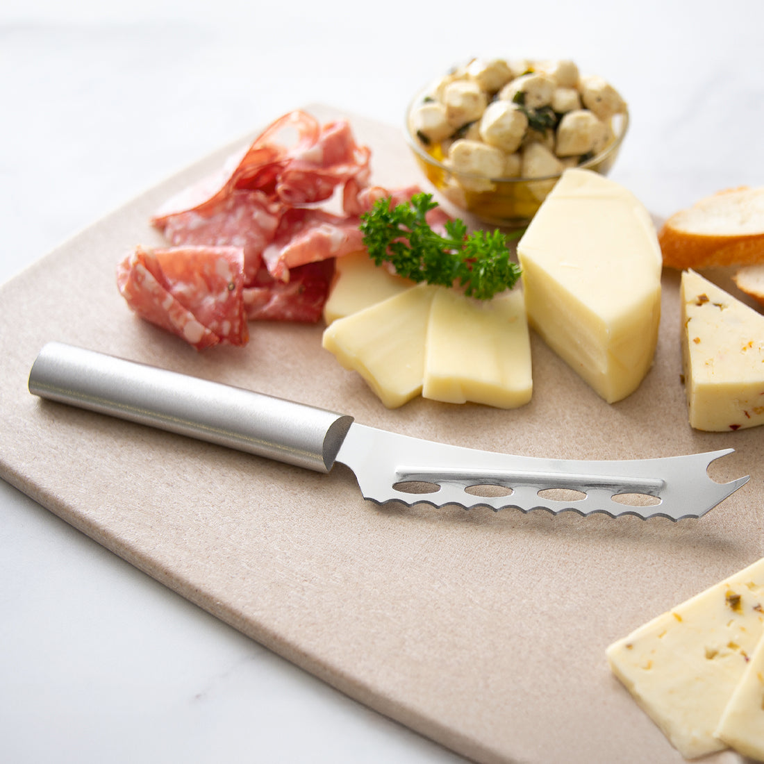 Silver Cheese Knife and meat platter with a cheese knife on a wooden board