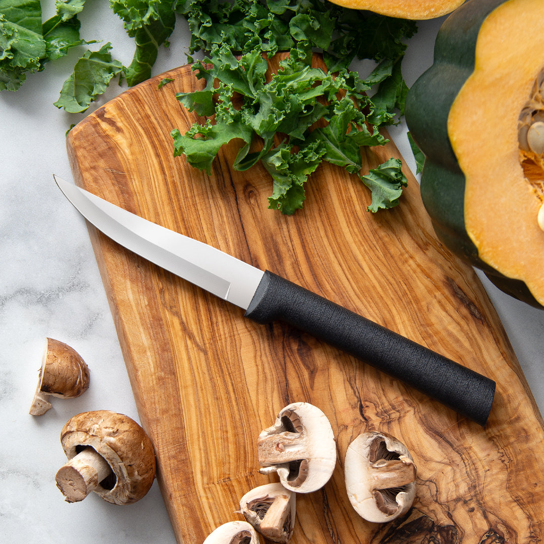 Figs and a knife on a dark surface