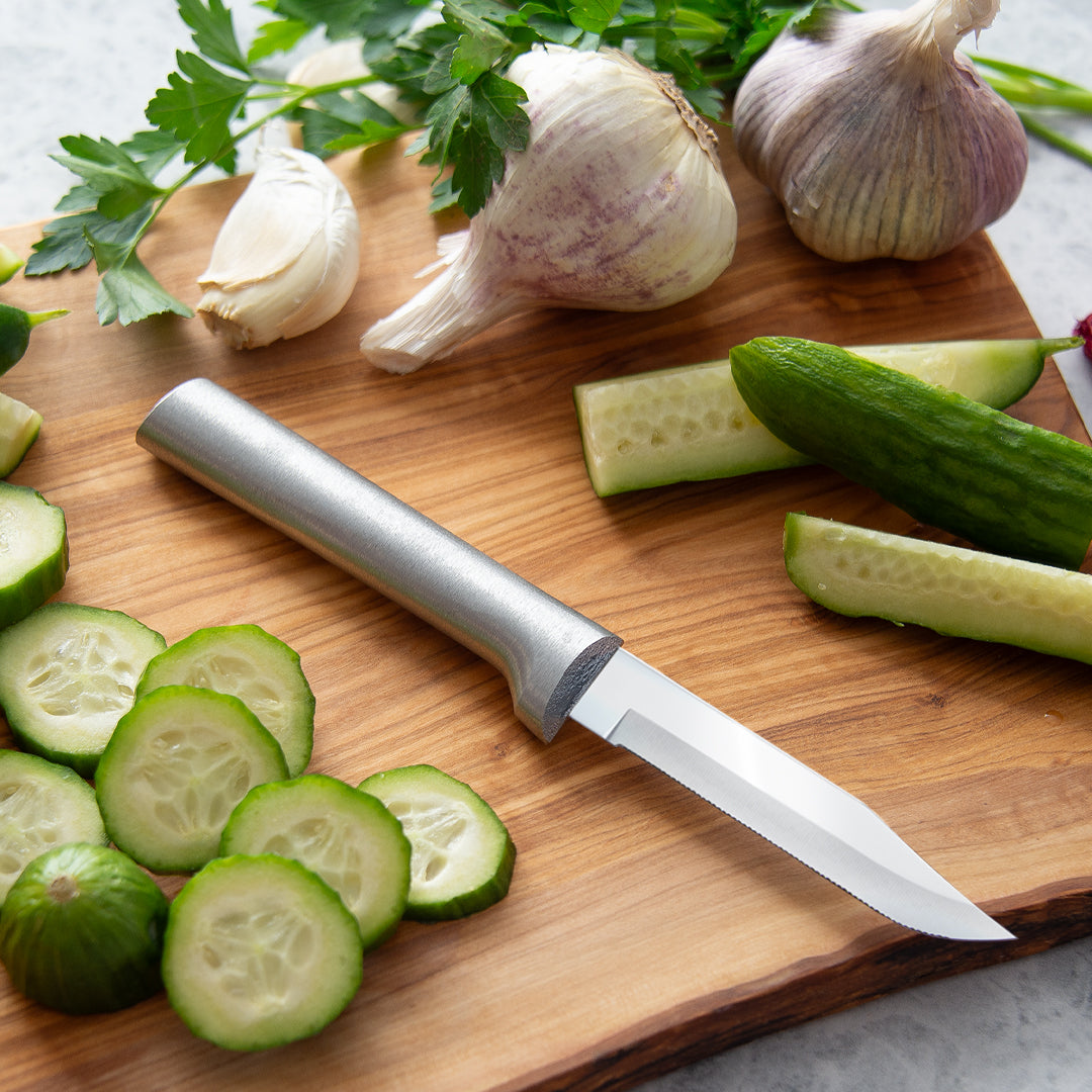 Rada Serrated Regular Paring on a cutting board with garlic and cucumber