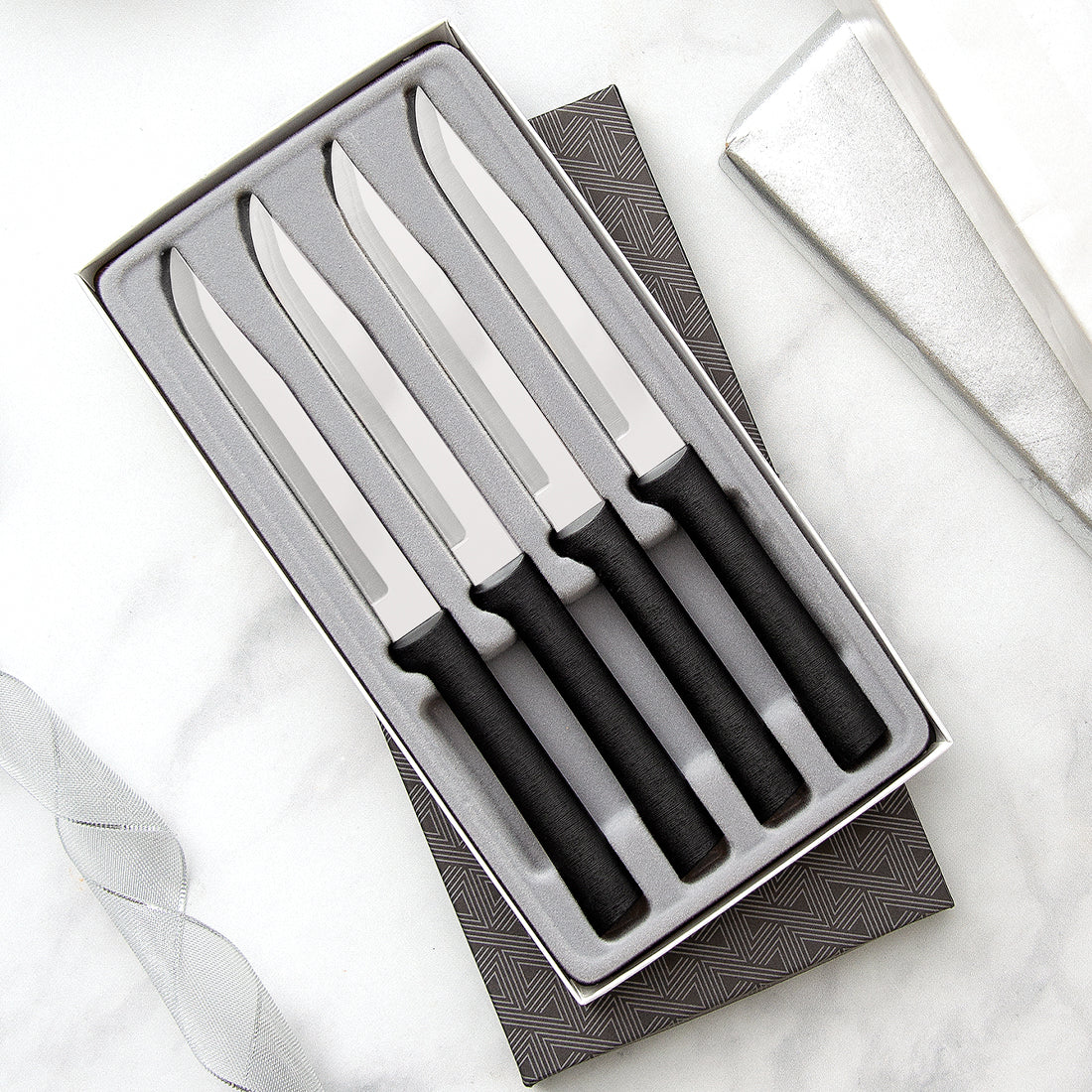 Four Utility/Steak Knives Gift Set with silver handles in a black-lined gift box. 