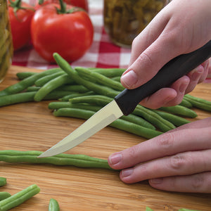 Heavy Duty Paring knife with black Anthem Wave handle in use slicing green beans on a cutting board