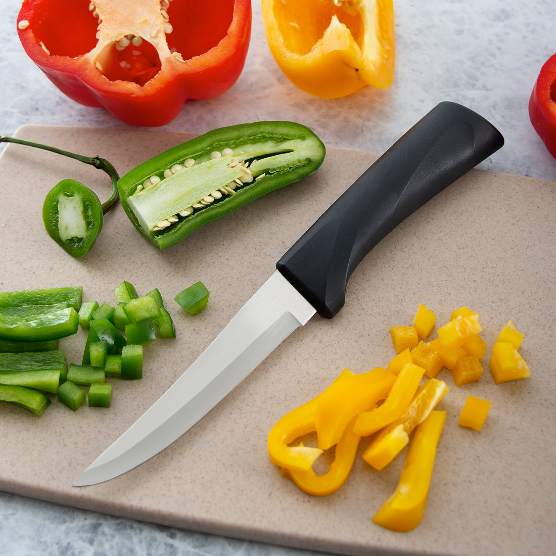Rada Cutlery Anthem Wave Super Parer on cutting board with peppers. 