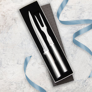 A meat carving gift set with a carving fork and carver-boner knife laying on a marbled counter top with a blue ribbon.