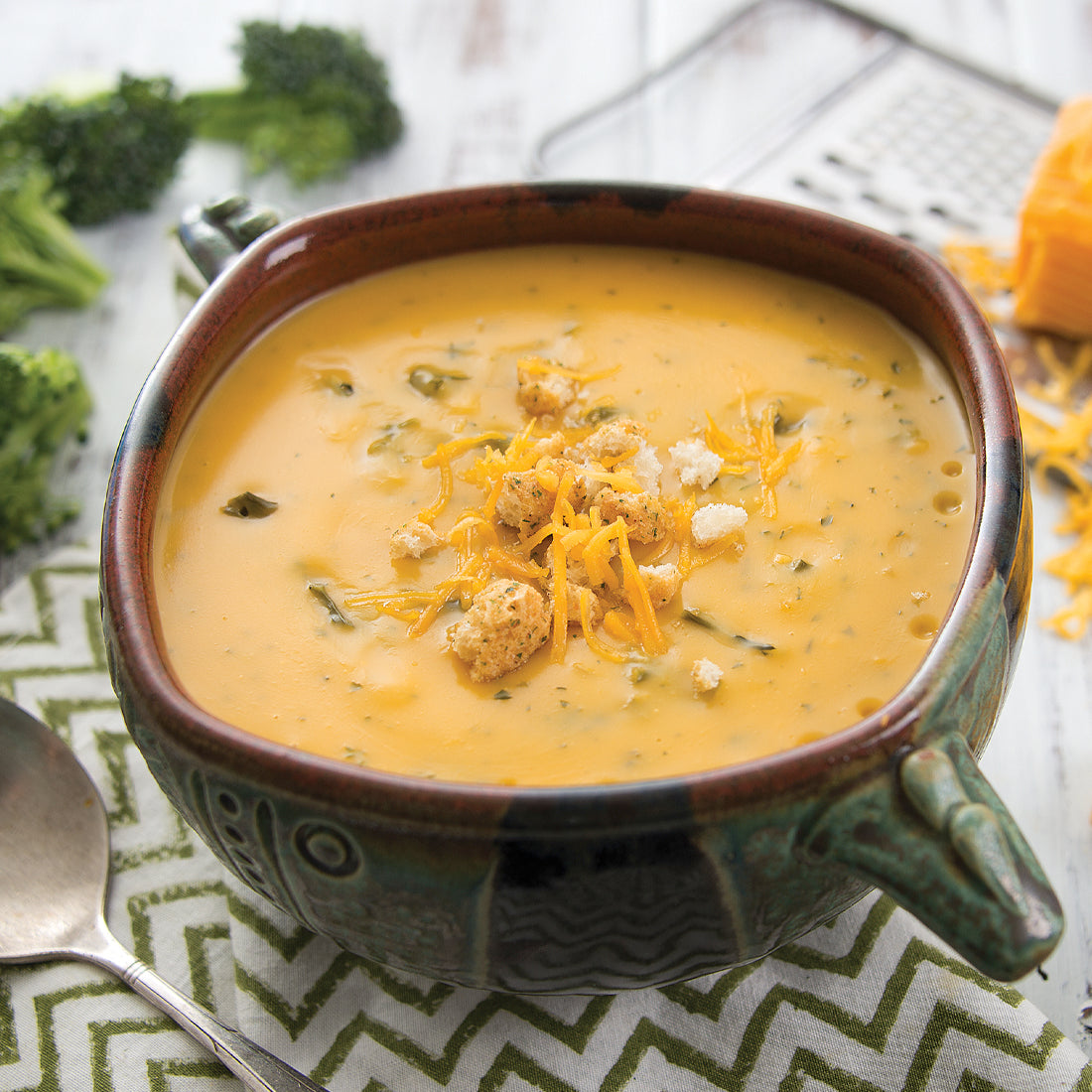 Prepared Cheddar Broccoli Soup in bowl garnished with cheese and croutons