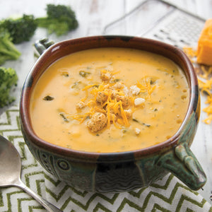 Prepared Cheddar Broccoli Soup in bowl garnished with cheese and croutons