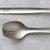 Cook's Spoon w/Holes on top of a sliced chicken salad with lettuce, tomatoes, and cucumber