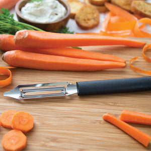 Deluxe Vegetable Peeler with black handle on a wooden board with carrots. 
