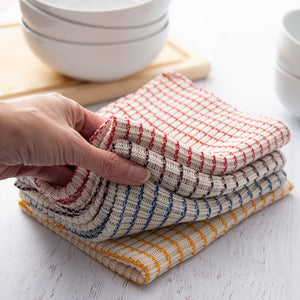 Four dishcloths being fanned out on a countertop.