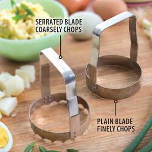 Two metal food choppers on a cutting board creating potato salad. Serrated blade coarsely chops. Plain blade finely chops.