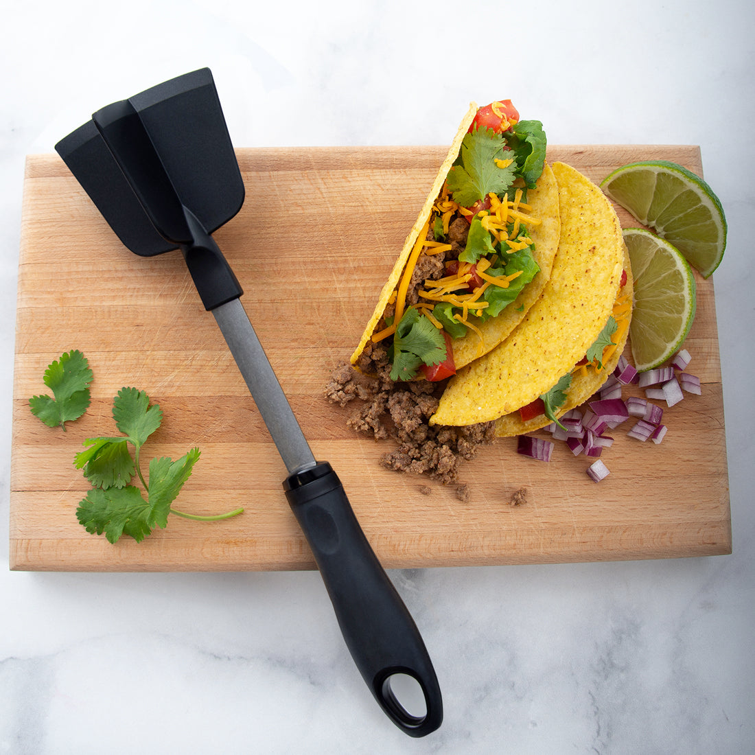 Rada Cutlery Meat Chopper with tacos on a cutting board.