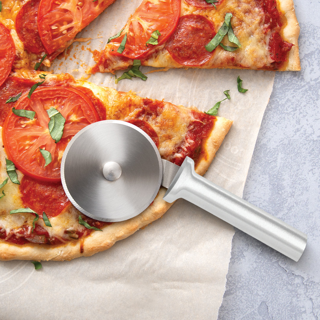 Rada Cutlery pizza cutter with silver handle and steel wheel on pizza slice. 