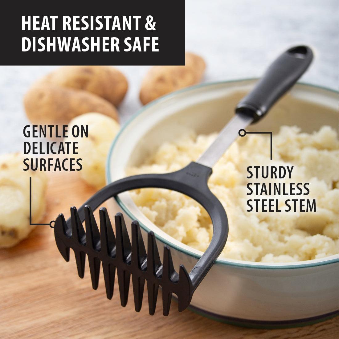 Potato Masher laying on cutting board, bowl of mashed potatoes with garnish, and whole potatoes.