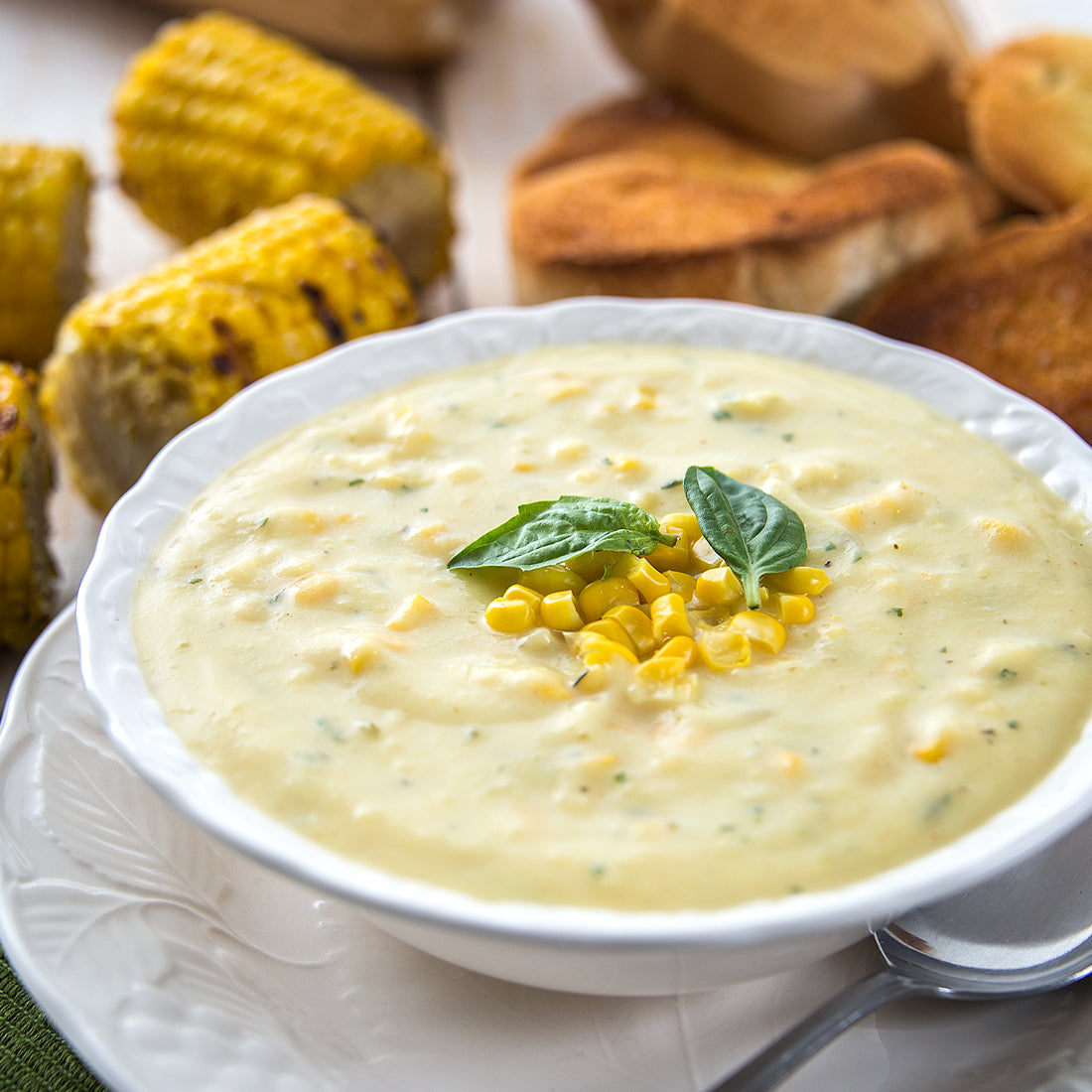 Roasted Corn Chowder in bowl garnished with basil.