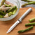 Silver handle Serrated Regular Paring on a brown cutting board with asparagus in a bowl, chopped up.