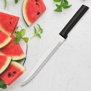 Rada's black handle Serrated Slicer on a white background next to watermelon slices with seeds, and leafy greens.