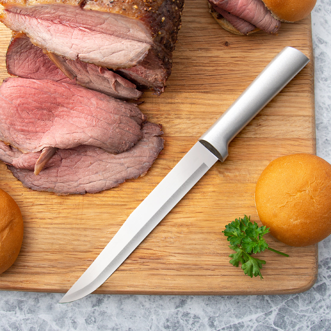 Rada Cutlery Slicer on a cutting board with sliced meat.