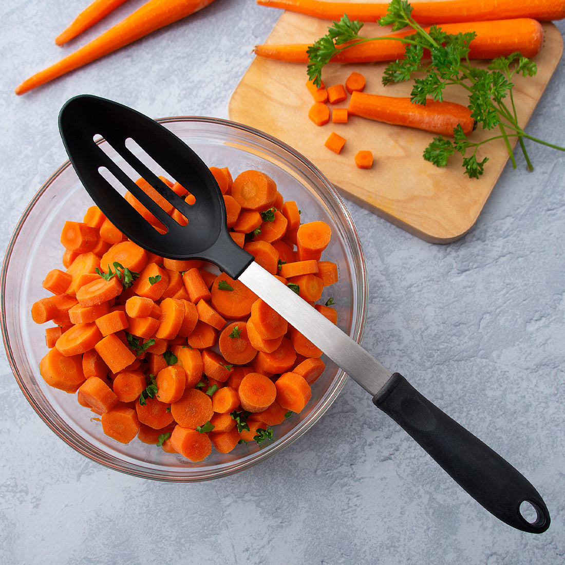 Rada Cutlery Slotted Spoon non-scratch utensil resting on bowl of cooked carrots. 
