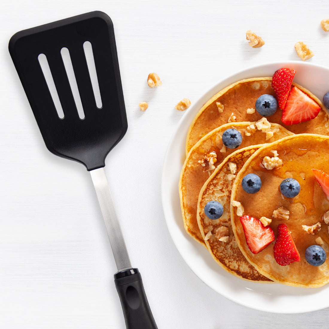 A non-scratch Slotted Turner with pancakes, blueberries, strawberries, and oatmeal.